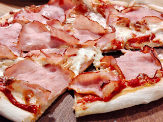 Sliced ham pizza with melted cheese and tomato sauce.