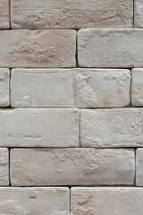 White brick wall with roughly surface. Building structure and interior decoration, background texture. Close-up.