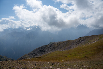 Fototapeta premium High-altitude alpine vegetation and granite rocks in the mountains of Kazakhstan. Scenic summer view of Malaya Almatinskaya Krugosvetka trekking route.