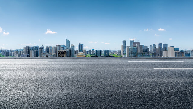 Empty asphalt road and modern city skyline with office buildings.