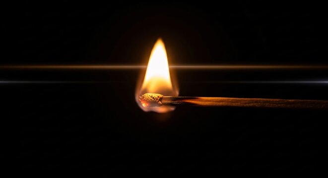 Close-up of a lit matchstick igniting a flame in a dark environment with warm glow and dramatic lighting for safety and fire concept photography - Powered by Adobe