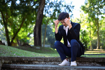 Fototapeta premium Office man stressed and sitting on outdoor steps in a green park