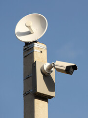 Surveillance system with an orange warning light located on a pole in the open. The threat of privacy and the protection of personal data. Security tracking on the streets of the city. Human mass