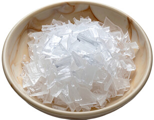 Close-up of a textured beige bowl filled with clear, fragmented plastic pieces