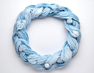 Braided blue fabric wreath adorned with floral embellishments against a white backdrop