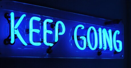 Obraz premium Bright neon sign displays Keep Going. Blue light radiates from lettering against dark background. Simple, motivational message.