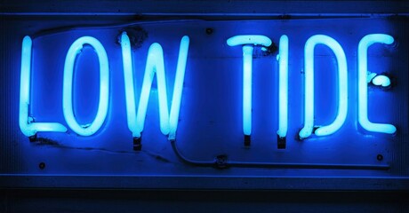 Obraz premium Bright blue neon sign displays words low tide. Dark background emphasizes glowing text. Simple, direct message.