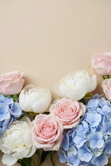 Flowers bouquet frame pastel colors on pale beige background with copy space. Floral card, greetings card mockup. Holiday flowers background