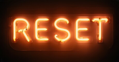 Bright neon sign displays word RESET. Orange glow contrasts dark background. Simple typography, modern aesthetic, impactful message.