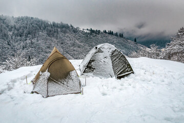 Two tourist tents in winter snowy mountains