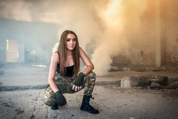 Woman in military clothes in ruined smoked building