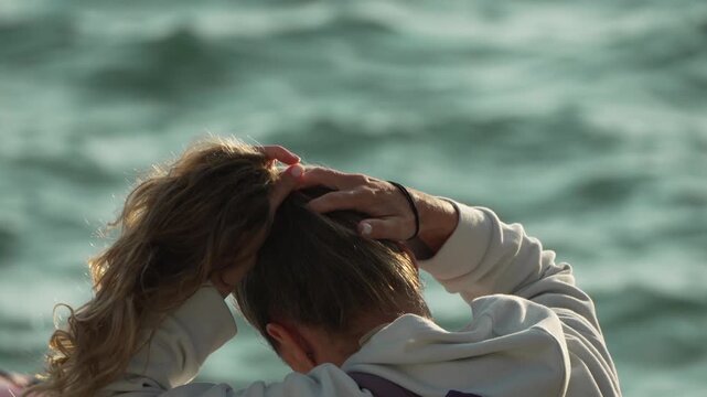 Woman hair beach young blonde woman tying her long ponytail on a sunny day by the ocean preparing for activity