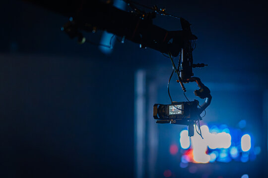 Camera mounted on robotic arm captures dynamic shots in a studio setting, showcasing advanced technology and creative filmmaking techniques in a vibrant atmosphere