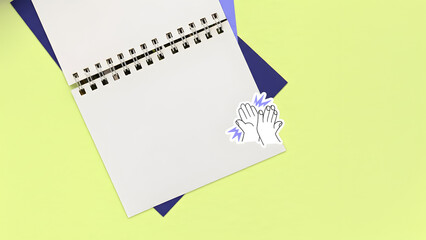 A spiral notebook lies open on a vibrant yellow background, inviting creativity and planning with its blank white pages.