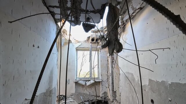 Inside a ruined apartment building after a drone attack showing devastating consequences, shattered doors, and destroyed floors in the aftermath of a bombing