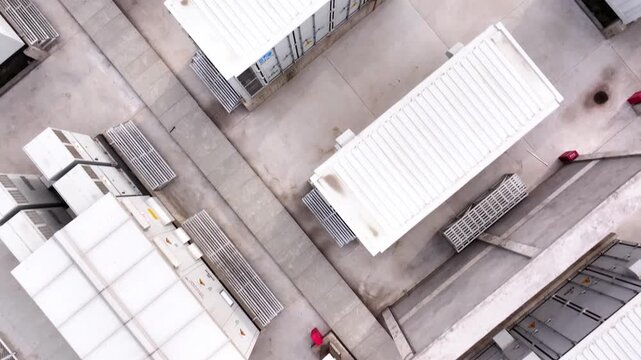 Numerous white containerized energy storage units arranged in neat rows outdoors