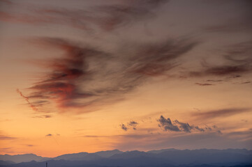 冬の夕暮れに染まる秩父連山と空を流れる雲の風景