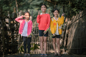 Obraz premium Happy Asian Girls Playing with Traditional Banana Rib Hobby Horses.