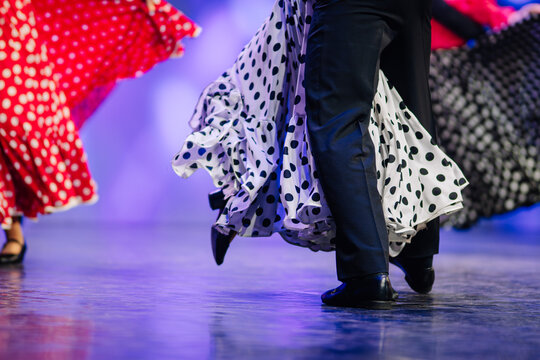 Colorful Latvian folk dancers in traditional attire showcase vibrant movements on stage, celebrating cultural heritage and joyful expression through dance - Powered by Adobe
