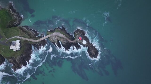 Aerial view of the Petit Minou Lighthouse connected by a narrow causeway, contrasting with the turbulent turquoise waters, Bretagne, France.