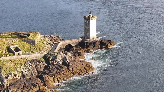 Aerial view of the Petit Minou Lighthouse standing tall against the crashing waves of the sea, Bretagne, France.