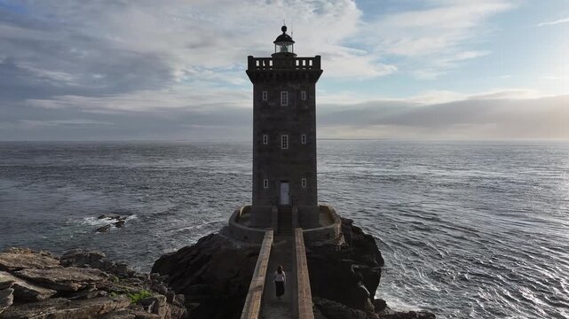 Aerial view of Petit Minou Lighthouse, a stone sentinel standing guard against the vast ocean, with a lone person walking towards it, Bretagne, France.