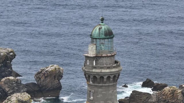 Aerial view of the Phare du Petit Minou lighthouse, a stunning gray stone structure against the dark blue ocean, Bretagne, France.