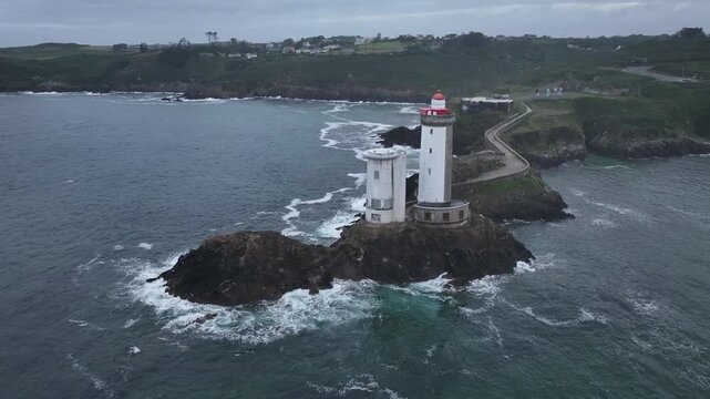 Aerial view of the Petit Minou lighthouse stands tall against the crashing waves, its white tower a beacon on the rocky coast, Bretagne, France.