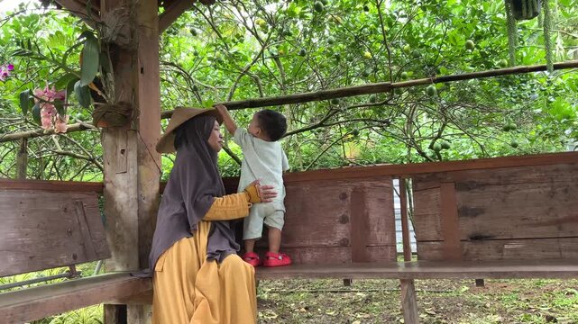 Joyful mother and child exploring a vibrant Citrus limon fruit tree garden