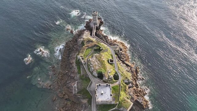 Aerial view of the Petit Minou lighthouse perched on a rocky outcrop where the turquoise waters meet the rugged coastline, Bretagne, France.