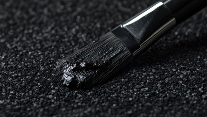 Close-up of a Paintbrush Loaded with Black Pigment on a Dark Surface