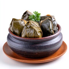 Traditional Asian rice dumplings wrapped in bamboo leaves served in a rustic bowl on a wooden plate with fresh herbs
