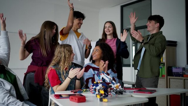 High school students working on robotics project. Girl in wheelchair among them.