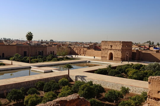 View of El Badi Palace ruins in Marrakech, Morocco, with historic walls, reflecting pools and gardens under clear blue sky, representing history and cultural heritage