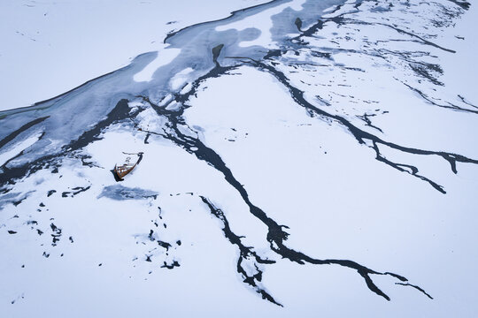 Aerial view of icy veins snaking through a vast, snow-covered landscape, carved by frigid waters in the heart of winter, Hvolsvollur, Iceland.