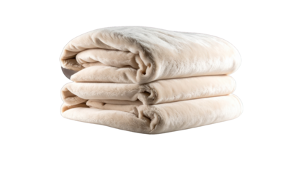 Stacked, folded beige blankets with a fluffy texture against a dark background