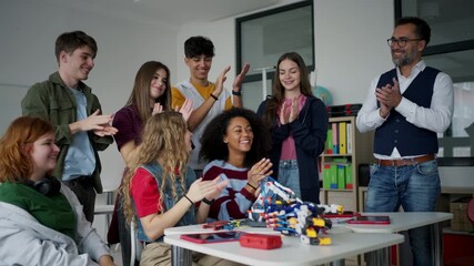 High school students working on robotics project with their teacher. Girl in wheelchair among them. - Powered by Adobe