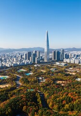 Elevated view captures expansive urban area contrasting with vibrant autumn foliage and distant mountains under clear sky