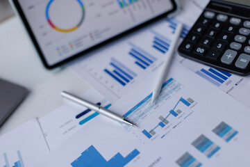 Financial accounting calculator report pen graphs and charts Preparing report.Business reports and pile of documents on gray reflection background.
