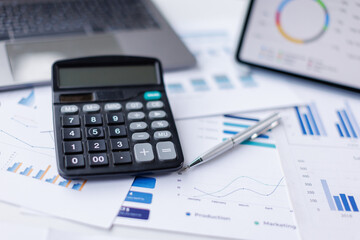 Financial accounting calculator report pen graphs and charts Preparing report.Business reports and pile of documents on gray reflection background.
