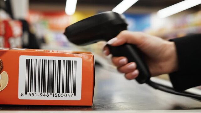 Hand scanning barcode on product at checkout