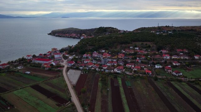 Aerial video of Lin village, autumn fields, and the peninsula extending into Lake Ohrid under soft morning light.