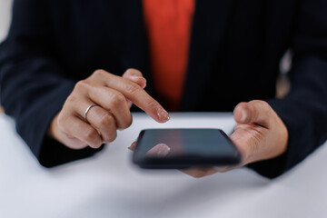 Closeup business woman using smartphone at office desk. Blank screen for advertising
