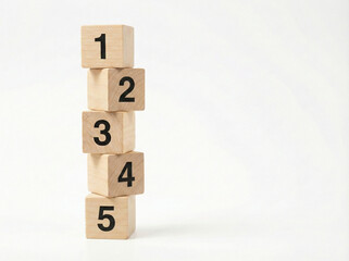 Criss cross stacked wooden number blocks from one to five positioned on left with clean copy space on right isolated on white background
