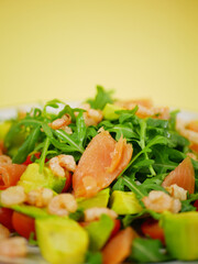 Vertical fresh salmon shrimp avocado arugula salad presented as a healthy step by step recipe showing clean ingredient layering for a simple dish. pro photo