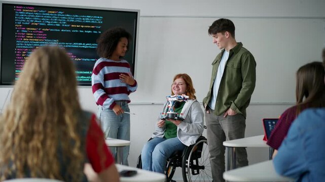 High school students working on robotics project. Girl in wheelchair among them.