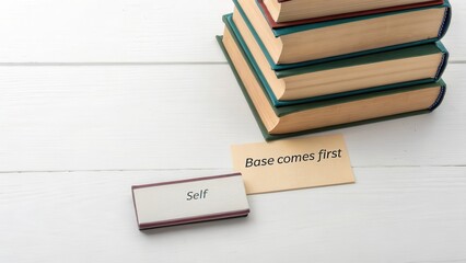 Stack of books with base message on wooden surface