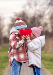cute boy and girl holding a red heart 