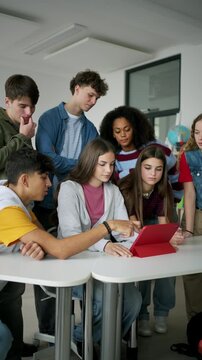 Teen students learning together with digital tablet in modern classroom.