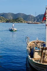 Obraz premium Picturesque Turkish coastal village with a striking white mosque featuring a green-topped minaret rising above terracotta-roofed houses along a serene waterfront. 